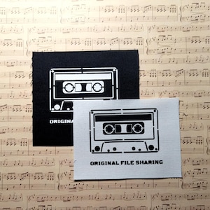 May include: Two white fabric patches with black cassette tape designs. The top patch says "ORIGINAL" and the bottom patch says "ORIGINAL FILE SHARING".