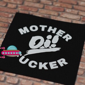 May include: Black fabric patch with white text that reads "Mother Oi!  Fucker".