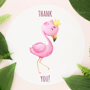 May include: A white card with a pink flamingo wearing a gold crown. The flamingo is standing on one leg and has its head tilted to the side. The card says "THANK YOU!" in brown text.