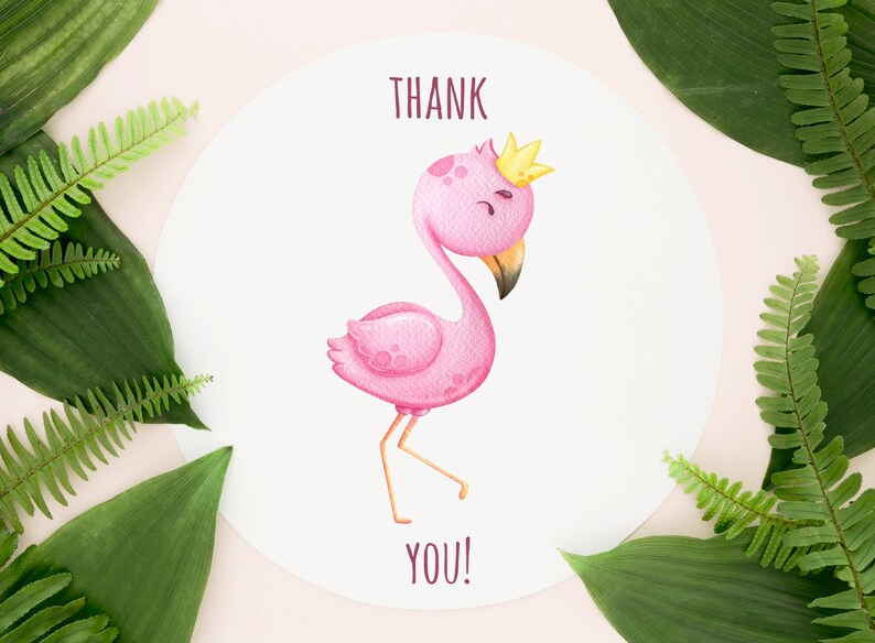 May include: A white card with a pink flamingo wearing a gold crown. The flamingo is standing on one leg and has its head tilted to the side. The card says "THANK YOU!" in brown text.
