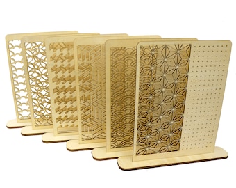 May include: Set of six wooden earring display stands featuring various geometric patterns. Each stand has a base and a vertical panel with a distinctive design.
