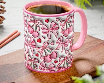 May include: A pink ceramic mug with a white background and a pattern of pink bows and cherries. The mug is filled with coffee.