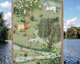 May include: A tapestry blanket featuring a pastoral scene with a lion, a white horse, a greyhound, a rabbit, and an owl. The blanket has a green background with trees, flowers, and a stream. The edges are fringed.