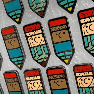 Puede incluir: Una colección de pines de esmalte con forma de lápiz de colores con diferentes expresiones faciales. Cada pin presenta un esquema de colores rojo, marrón, azul, verde y amarillo.