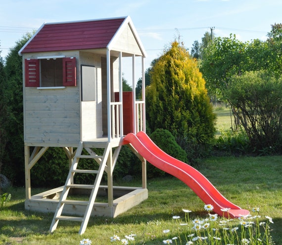 wooden playhouse with slide and sandpit