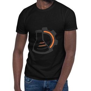 Op de afbeelding: Een zwart T-shirt met een afbeelding van een bekerglas en een tandwiel. Het tandwiel is oranje en het bekerglas is grijs.