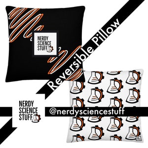 Op de afbeelding: Wendbaar kussen met twee ontwerpen. De ene kant heeft een zwarte achtergrond met oranje en witte golvende lijnen en de tekst "Nerdy Science Stuff". De andere kant heeft een witte achtergrond met een herhalend patroon van bekers en tandwielen in oranje en zwart.