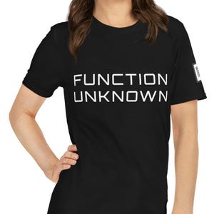 May include: A black short-sleeved t-shirt featuring the white text "FUNCTION UNKNOWN" printed in a clean, sans-serif font across the chest. The garment has a classic crew neckline and a small square label detail on the left sleeve.