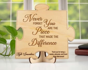 Può includere: Pezzo di puzzle in legno con il testo "Non dimenticare mai che sei il pezzo che ha fatto la differenza". Il pezzo del puzzle è su un supporto e ha il nome "Kyle Saunders" inciso sul fondo. Il testo "Grazie per essere stato un mentore, un sostenitore e un amico. Goditi la pensione!" è anche inciso sul pezzo.