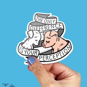 May include: A sticker featuring a black and white illustration of a dog and a pig with the text "The only difference is your perception".