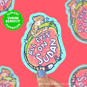 Puede incluir: Una pegatina con un guepardo de dibujos animados abrazando una sandía rosa y verde con el texto "All Eyes On Sudan". La pegatina está sobre un fondo rosa y tiene un círculo verde con el texto "Support Sudan Benefit Fundraiser" en la esquina superior izquierda.
