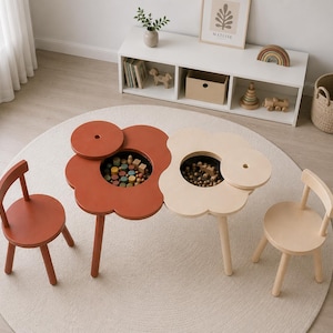 Könnte beinhalten: Ein Set aus zwei blumenförmigen Holztischen und zwei passenden Stühlen in Terrakotta und Creme. Jeder Tisch verfügt über einen abnehmbaren runden Deckel, der ein zentrales Staufach mit kleinen Holzklötzen und Holzkugeln freigibt.