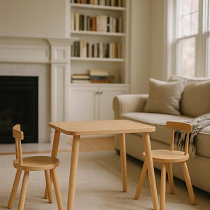 May include: A light-colored wooden table with rounded corners and four tapered legs, accompanied by two matching chairs. Each chair features a circular seat, a curved backrest, and four splayed legs, creating a coordinated furniture set.