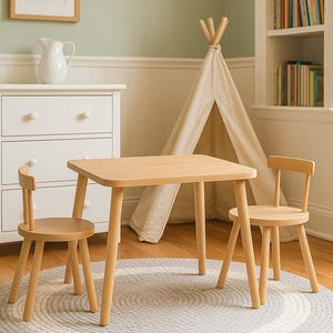 May include: A light-colored wooden table with rounded corners and four tapered legs, accompanied by two matching wooden chairs with low backrests, all positioned on a circular gray and white braided rug in a room with light wood flooring.