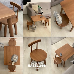 May include: A light brown wooden children's table and two chairs set with rounded edges and cylindrical legs. The set features the text WOOD TONE HAZEL 3441 H 46. The furniture has a smooth finish and a simple design, suitable for a play area.