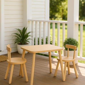 May include: A light-colored wooden table with rounded corners and four tapered legs, accompanied by two matching chairs with circular seats and low backrests, all featuring a smooth, natural wood grain finish and a simple, functional design.