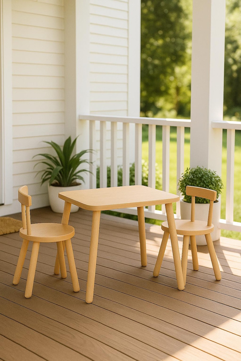 May include: A light-colored wooden table with rounded corners and four tapered legs, accompanied by two matching chairs with circular seats and low backrests, all featuring a smooth, natural wood grain finish and a simple, functional design.