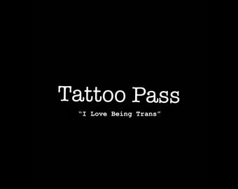 May include: Black and white text on a black background that reads "Tattoo Pass" and "I Love Being Trans".