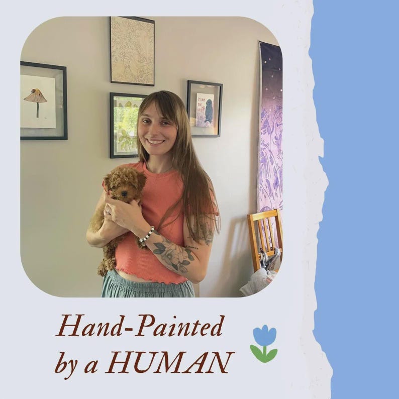 Może przedstawiać: Uśmiechnięta kobieta trzyma małego, brązowego psa. Obraz zawiera oprawione dzieła sztuki na ścianie i tekst "Hand-Painted by a HUMAN" z kwiatową grafiką.