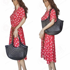 May include: Two mannequins display a black woven tote bag. The bag has a rounded shape with a handle. The mannequins wear a red dress with white floral patterns and a brown belt. The text "MONALISA MEDIUM" is at the top.