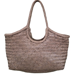 May include: A woven tote bag in a neutral taupe color. The bag features a braided handle and a basket weave design. The open top bag is suitable for carrying groceries or other items. The bag is made of a durable material.