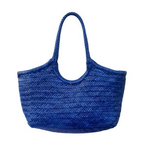 May include: A vibrant blue woven tote bag with a braided handle. The bag features a textured, basket-weave design and a curved top edge. The bag is a solid, bright blue color, perfect for carrying items.