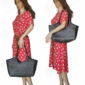 May include: Two mannequins display a large, black woven tote bag. The bag has a rectangular shape with a woven pattern and two handles. The mannequins are wearing red dresses with white floral patterns. The text "MONALISA BIG" is at the top.