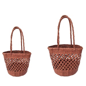 May include: Two woven brown tote bags with braided handles. The bags have an open weave design, allowing visibility of the contents. The bags are made of a natural material, likely straw or a similar fiber.