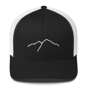 Könnte beinhalten: Schwarz-weiße Trucker-Cap mit einem weißen, aufgestickten Bergmotiv auf der Vorderseite. Die Kappe hat eine schwarze Front und einen Schirm sowie eine weiße Mesh-Rückseite. Eine klassische, verstellbare Kappe.