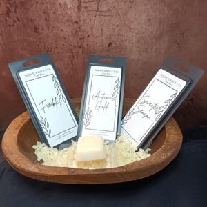 Puede incluir: Tres etiquetas de embalaje de fusión de cera de soja con bordes negros y texto blanco. Las etiquetas son para las fragancias "Freckles", "Autumn Gold" y "Sweater Season".