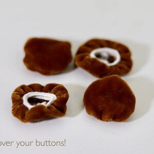 May include: Four brown velvet button covers with white elastic bands. The text "Slip me over your buttons!" is at the bottom of the image.