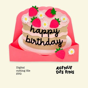 May include: A layered paper cake with pink frosting, strawberries, and daisies, with the words "happy birthday" in black script. The cake sits on a white plate within a pink card. The words "AVENUE DES PINS" are also visible.