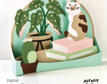 May include: A digital cutting file for a 3D paper craft featuring a cat sitting on a stack of books, a potted plant, and a cactus. The design is in a light green, brown, and white color scheme. The file is for use with a cutting machine and is perfect for creating a unique and personalized home decor piece.