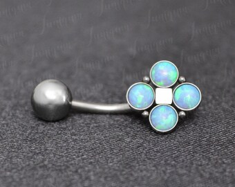 May include: A silver-colored belly button ring with a curved barbell and a decorative end featuring four light blue opal-like stones arranged in a flower shape, with a small white square in the center.
