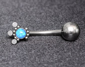 May include: A silver belly button ring with a blue opal gemstone and a small ball on the other end.