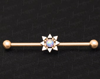 Puede incluir: Barbell de oro con un encanto en forma de estrella con una piedra de ópalo iridiscente. El barbell es un artículo de joyería para piercings corporales.