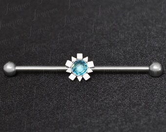Puede incluir: Una barra de barbell de plata con una gema azul engastada en un diseño de estrella plateada. La barra tiene un diámetro de 10 mm.