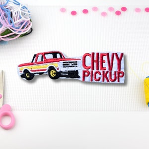 May include: Red and yellow embroidered patch of a Chevy pickup truck with the text "CHEVY PICKUP" in red.