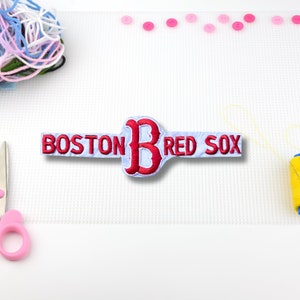 May include: White embroidered patch with red lettering that reads "BOSTON RED SOX" with a red embroidered "B" in the center.