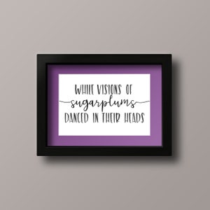 May include: A framed print with a purple background and white text that reads "While visions of sugarplums danced in their heads."