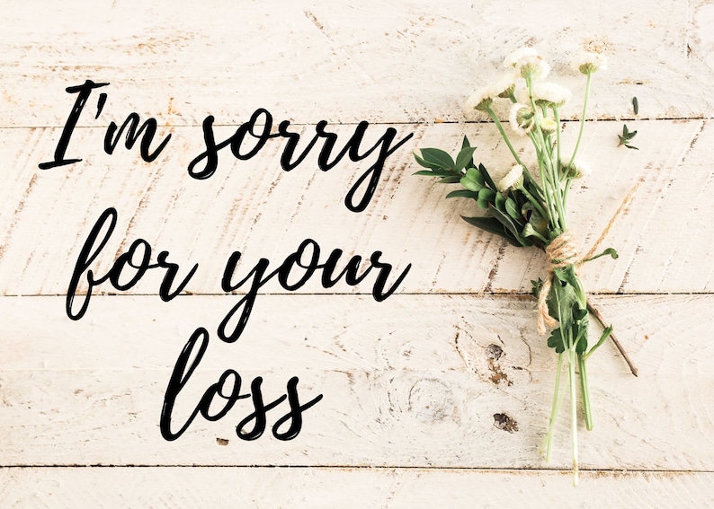 May include: White wooden background with the text "I'm sorry for your loss" written in black cursive. A bouquet of white flowers with green leaves is tied with twine on the right side of the image.