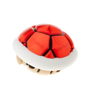 May include: A red and white shell with a spiky, segmented top. This is a classic video game item.