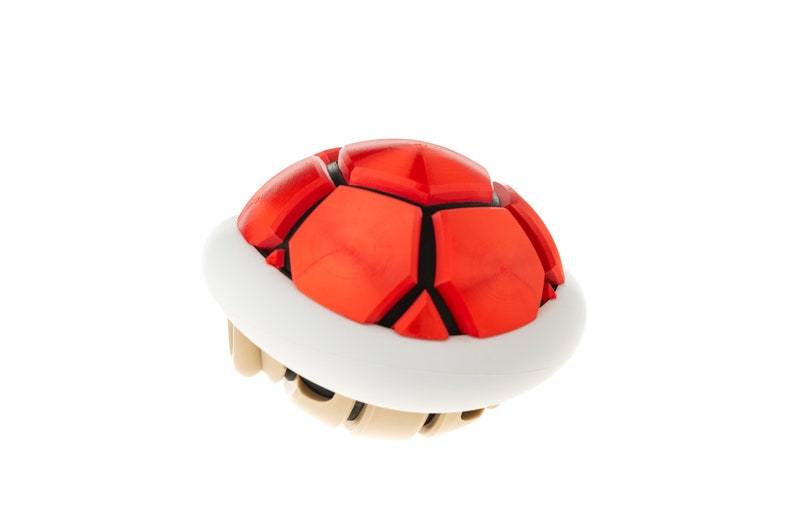 May include: A red and white shell with a spiky, segmented top. This is a classic video game item.