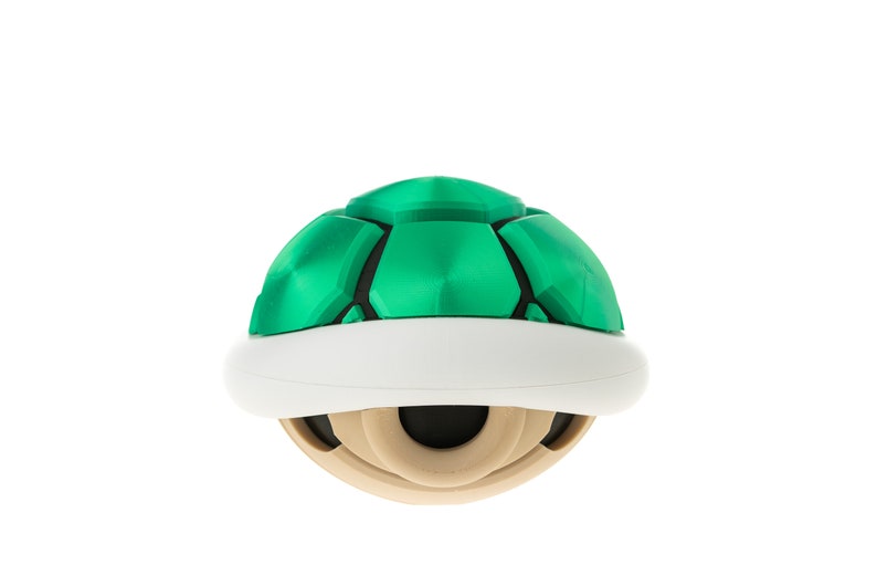 May include: A green and white shell-shaped object with a textured surface. It is a video game character from the Super Mario franchise.