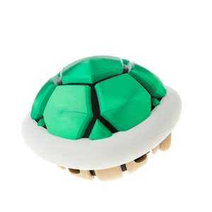May include: A green and white shell with a textured surface, resembling a turtle shell. This is a popular item in video games.