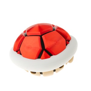 May include: A red and white plastic toy shell, resembling a turtle shell, with a textured surface.