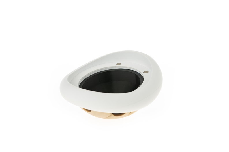 May include: White ceramic bowl with a black interior and two small holes on the rim. The bowl is shaped like a rounded oval and has a slightly raised lip.