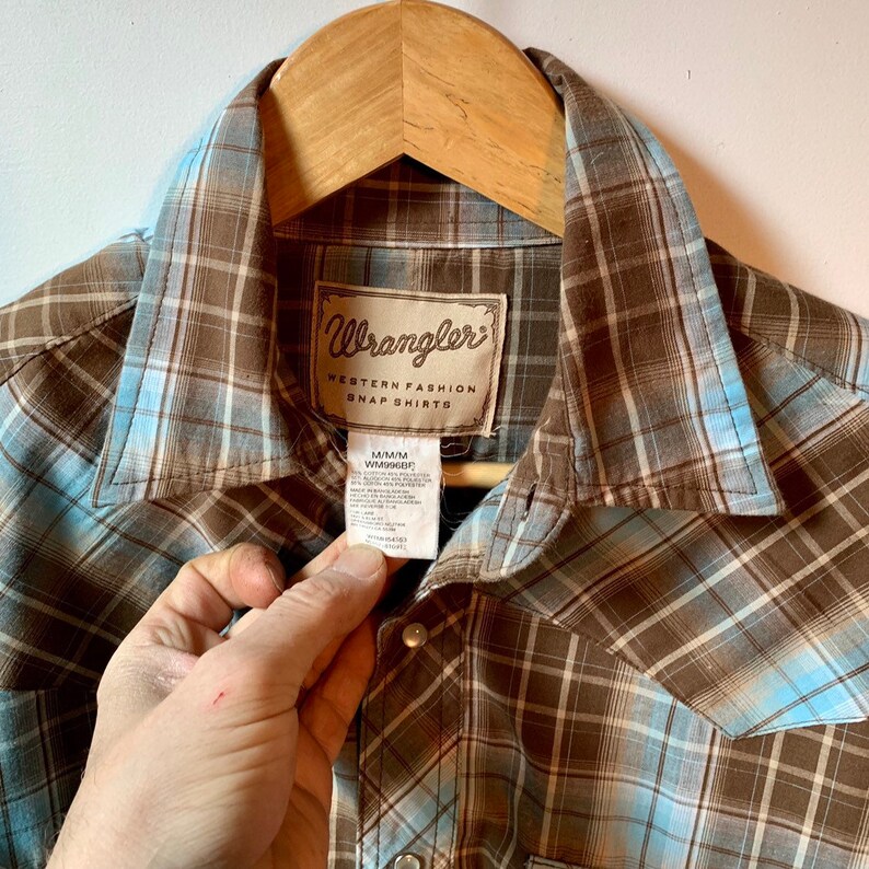 Wrangler western snapfront with sawtooth pocket flaps Medium classic plaid with white pearl snaps.