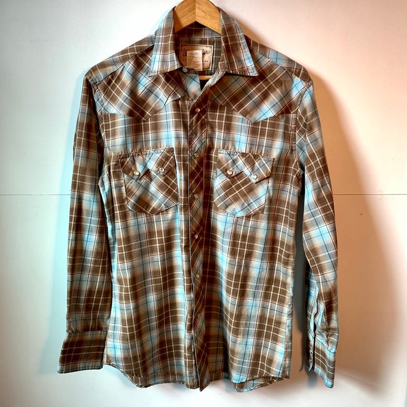 Wrangler western snapfront with sawtooth pocket flaps Medium classic plaid with white pearl snaps.