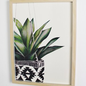 Puede incluir: Una ilustraci&oacute;n enmarcada de una planta verde colgando en una maceta con estampado geom&eacute;trico en blanco y negro.